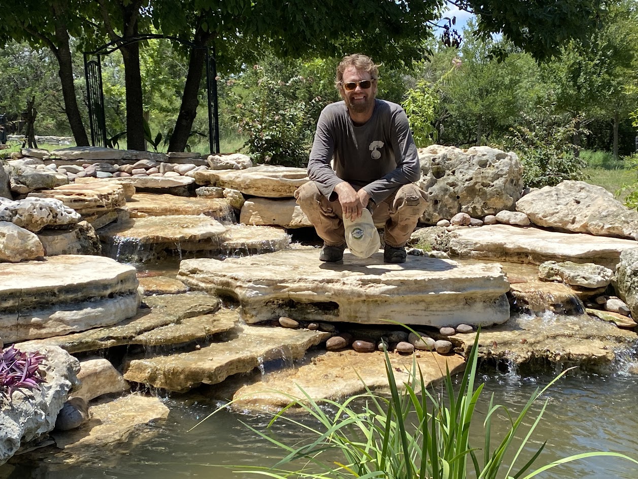 Owner of Stonebridge Ponds & Waterfalls Eric Arntson standing near a pond he designed and built.